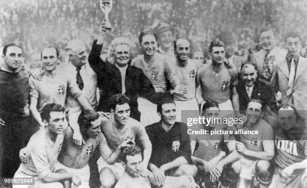 Proud and happy team coach Vittorio Pozzo is holding the "Coupe du Monde". From left: Amedeo Biavati, General Vaccaro, president of the Italian...