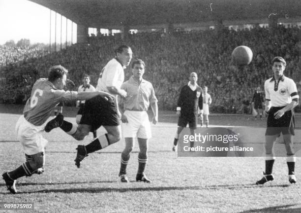 Saarland's Philippi and Puff fail to prevent Germany's Max Morlock's header, Dutch referee van der Meer and German player Hans Schaefer watching...