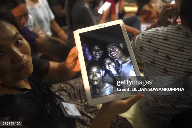 Thanaporn Promthep, mother of one of the 12 missing boys, displays an image believed to have been taken in 2017 of her son Duangpetch Promthep,...