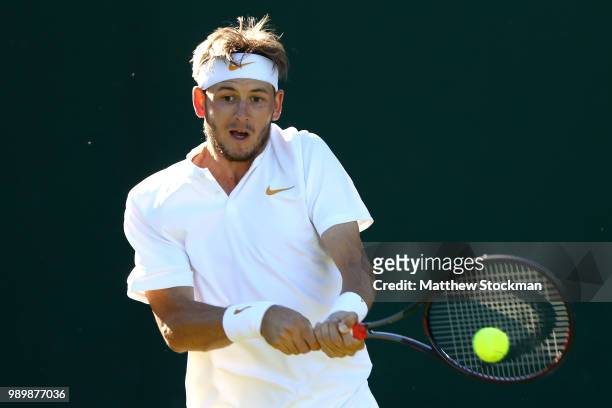 Jared Donaldson of the United States returns against Malek Jaziri of Tunisia on day one of the Wimbledon Lawn Tennis Championships at All England...