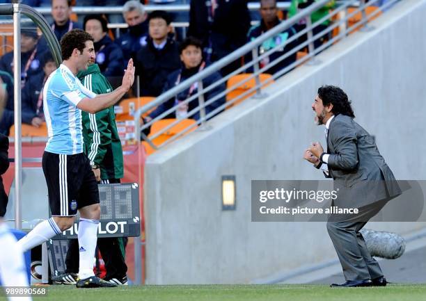 Argentina's coach Diego Armando Maradona celebrates with three-time-goalscorer Gonzalo Higuain during the 2010 FIFA World Cup group B match between...