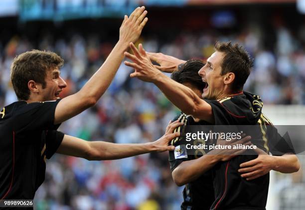 Miroslav Klose of Germany celebrates with Mesut Oezil and Thomas Mueller after scoring during the FIFA World Cup 2010 quarterfinal match between...