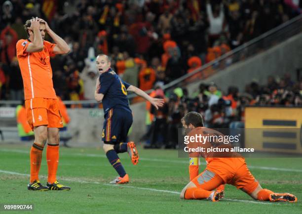 Spain's Andres Iniesta celebrates scoring the winning goal as Dutch Joris Mathijsen , Rafael van der Vaart are beaten during the 2010 FIFA World Cup...