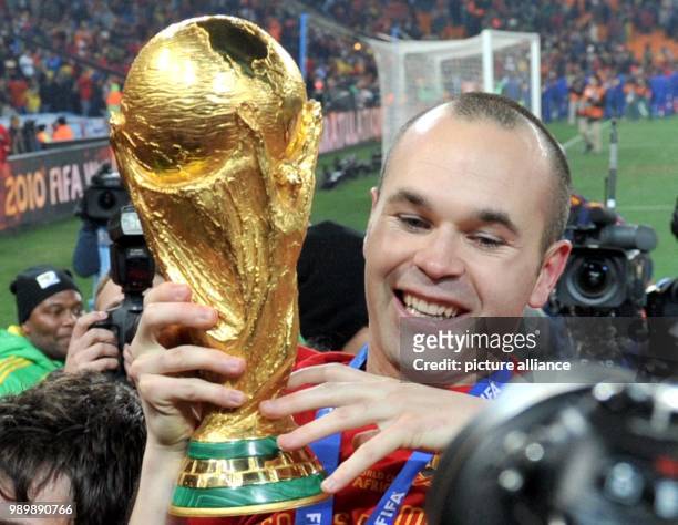 Andres Iniesta of Spain celebrates with the trophy after the 2010 FIFA World Cup final match between the Netherlands and Spain at the Soccer City...