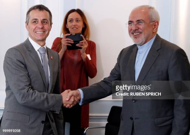 Iranian Foreign Minister Mohammad Javad Zarif shakes hands as he is welcomed by Swiss Foreign Minister Ignazio Cassis in Bern on July 2, 2018.