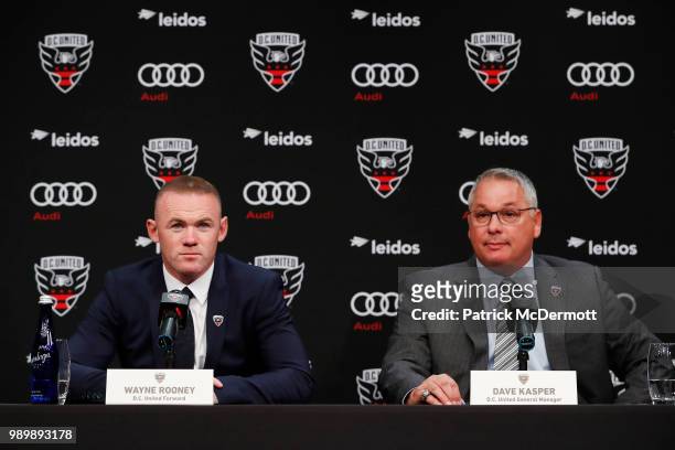 United General Manager Dave Kasper listens as Wayne Rooney of DC United speaks during his introduction press conference at The Newseum on July 2,...
