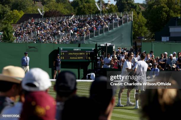 John-Patrick Smith and Andreas Seppi shake hands over the net after their game at All England Lawn Tennis and Croquet Club on July 2, 2018 in London,...
