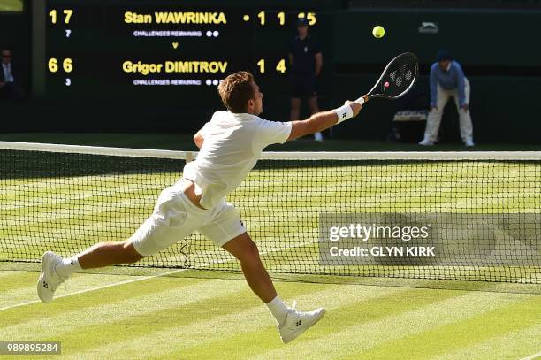 Switzerland's Stan Wawrinka returns to Bulgaria's Grigor Dimitrov during their men's singles first round match on the first day of the 2018 Wimbledon...