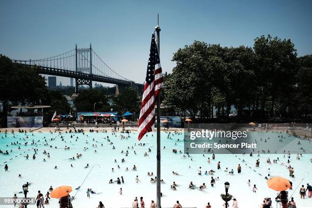 People enjoy a hot afternoon at the Astoria Pool in the borough of Queens on July 2, 2018 in New York City. New York City and much of the East Coast...