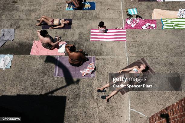 People enjoy a hot afternoon at the Astoria Pool in the borough of Queens on July 2, 2018 in New York City. New York City and much of the East Coast...