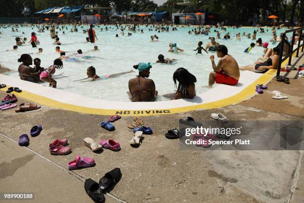 People enjoy a hot afternoon at the Astoria Pool in the borough of Queens on July 2, 2018 in New York City. New York City and much of the East Coast...