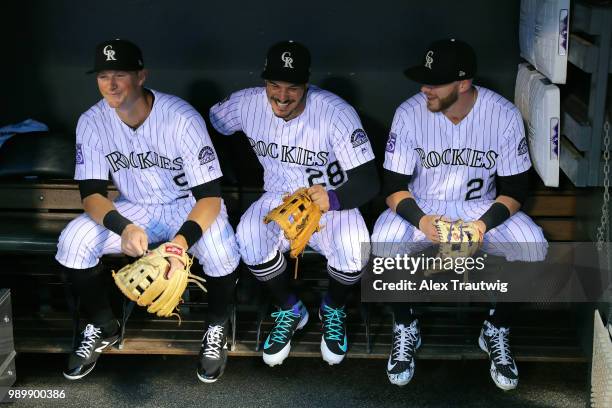 LeMahieu, Nolan Arenado, and Trevor Story of the Colorado Rockies sit in the dugout ahead of a game against the New York Mets at Coors Field on...