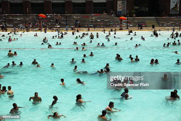 People enjoy a hot afternoon at the Astoria Pool in the borough of Queens on July 2, 2018 in New York City. New York City and much of the East Coast...