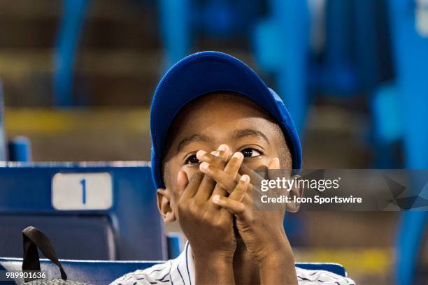 Young boy a Jay's fan covers his face with his hands before the MLB game between the Detroit Tigers and the Toronto Blue Jays at Rogers Centre in on...