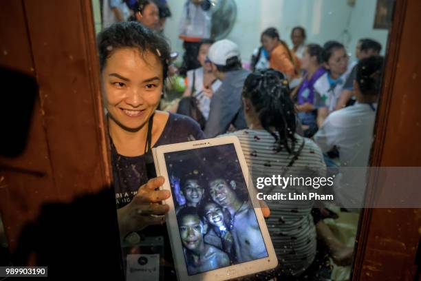 Relatives of the missing boys show photos of them after the 12 boys and their soccer coach have been found alive in the cave where they've been...