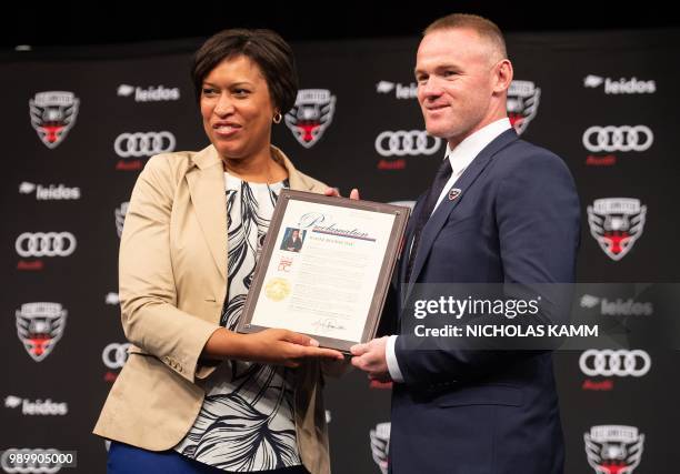 United's new recruit British footballer Wayne Rooney poses with DC mayor Muriel Bowser after she proclaimed Wayne Rooney Day at a press conference in...