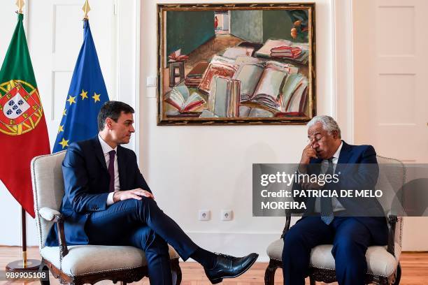 Portuguese Prime Minister Antonio Costa speaks with his Spanish counterpart Pedro Sanchez during a meeting at Comercio square in Lisbon on July 2,...