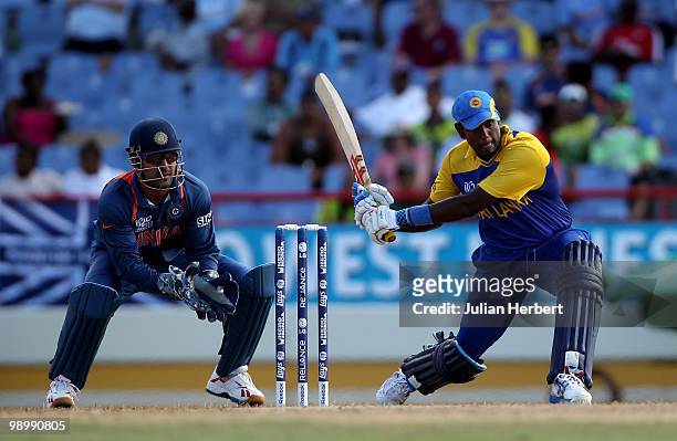 Dhoni of India looks on as Angelo Mathews hits out during the ICC Super Eight match between India and Sri Lanka played at the Beausejour Cricket...