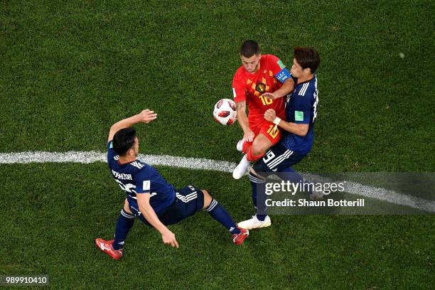 Eden Hazard of Belgium is challenged by Maya Yoshida and Hiroki Sakai of Japan during the 2018 FIFA World Cup Russia Round of 16 match between...