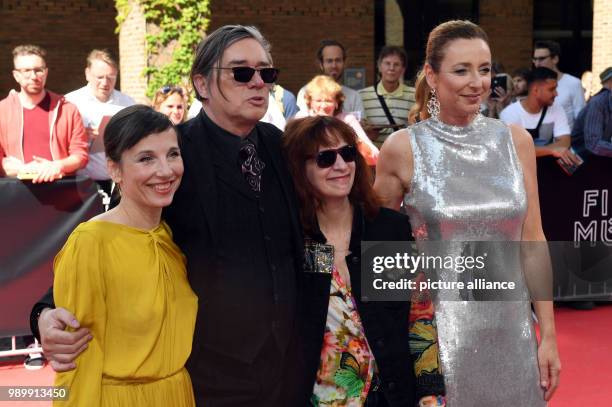 July 2018, Germany, Munich: Actress Meret Becker , musician Blixa Bargeld, and actress Amanda Plummer, being greeted on the red carpet before the...