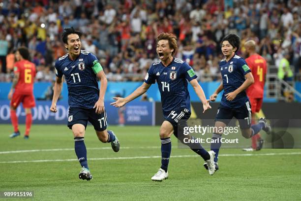 Takashi Inui of Japan celebrates with team mates Makoto Hasebe and Gaku Shibasaki after scoring his team's second goal during the 2018 FIFA World Cup...