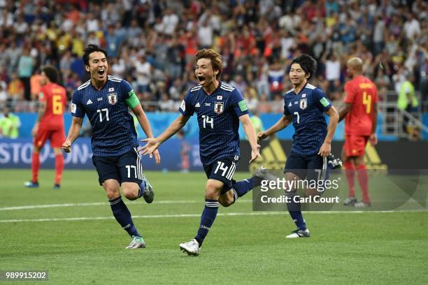 Takashi Inui of Japan celebrates with team mates Makoto Hasebe and Gaku Shibasaki after scoring his team's second goal during the 2018 FIFA World Cup...