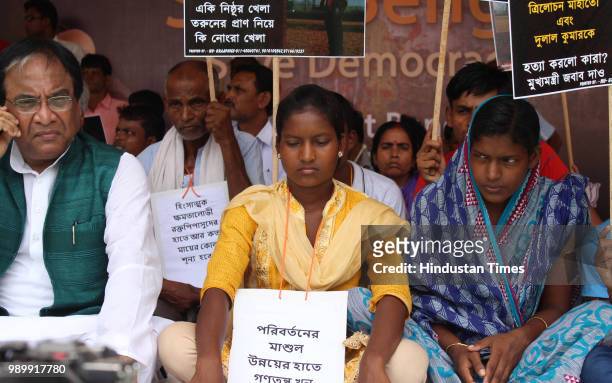 Activists with the family members of Trilochan Mahato and Dulal Kumar who were killed after the West Bengal panchayat election protest against their...