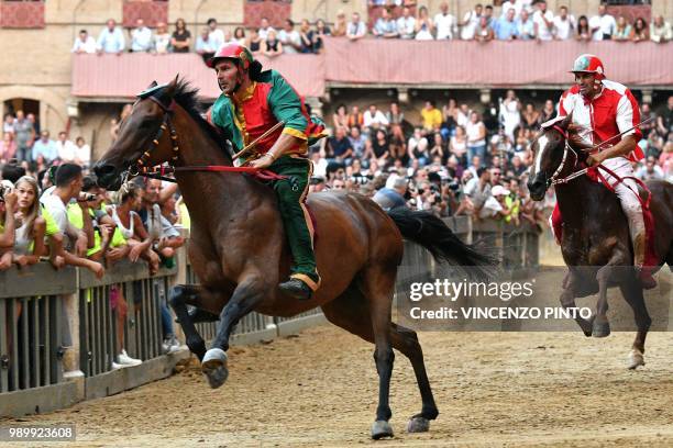 Jockey of the contrada "Drago" Andrea Mari competes with his horse Rocco Nice and wins the historical Italian horse race Palio di Siena on July 2 in...