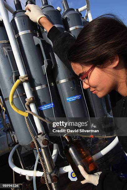 An Israeli researcher fills bottles from a scientific instrument on the deck of EcoOcean's marine research vessel Mediterranean Explorer after...