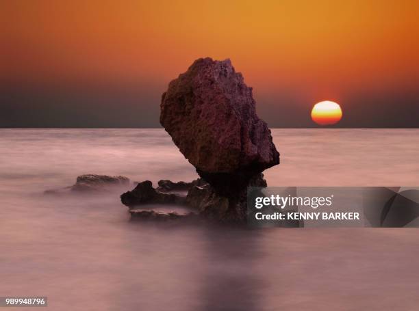 rock formation in sea at sunset - kenny arena fotografías e imágenes de stock