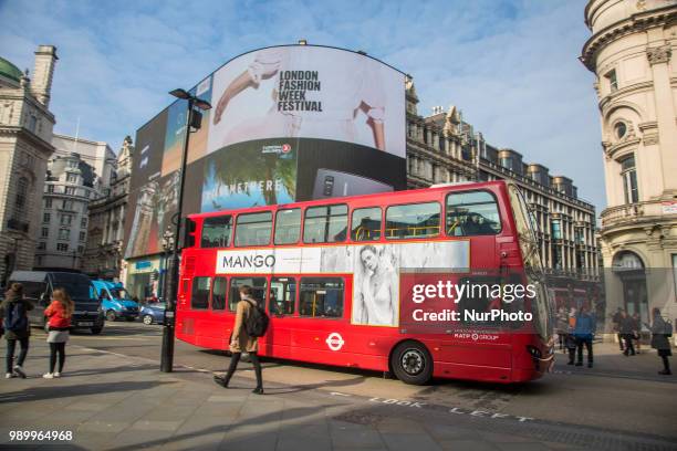 Tourists and locals walking in Piccadilly Circus or sitting on the steps of the Shaftesbury Memorial Fountain in Piccadilly Circus in City of...