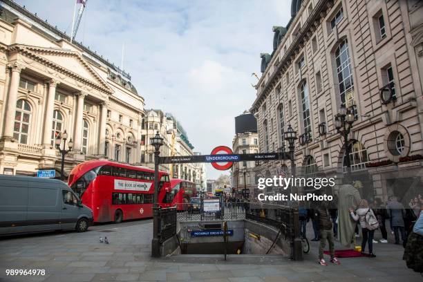 Tourists and locals walking in Piccadilly Circus or sitting on the steps of the Shaftesbury Memorial Fountain in Piccadilly Circus in City of...