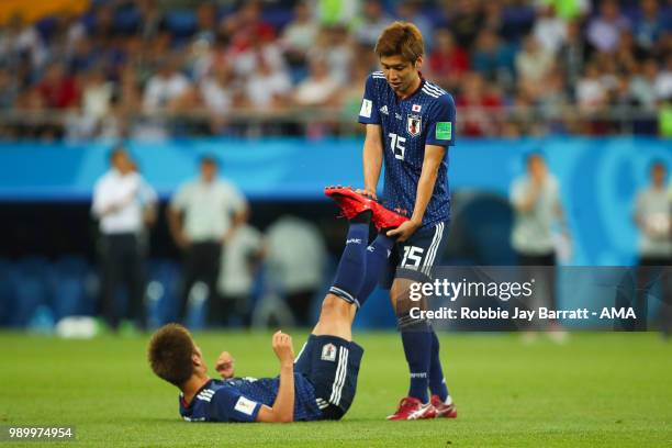 Yuya Osako of Japan helps team-mate Genki Haraguchi of Japan with cramp during the 2018 FIFA World Cup Russia Round of 16 match between Belgium and...