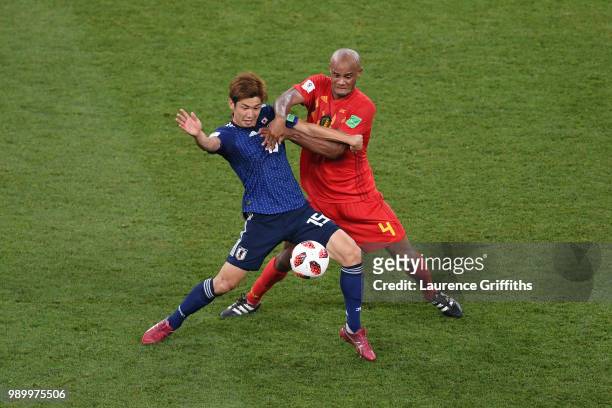 Yuya Osako of Japan is tackled by Vincent Kompany of Belgium during the 2018 FIFA World Cup Russia Round of 16 match between Belgium and Japan at...