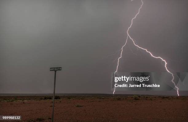 lightning bolt on a remote arizona road. - forked lightning stock pictures, royalty-free photos & images