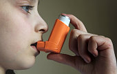 Yang girl holding asthma inhaler