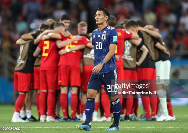 The Belgium team celebrate as Tomoaki Makino of Japan looks dejected following his sides defeat in the 2018 FIFA World Cup Russia Round of 16 match...