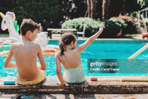 kids at edge of pool, kicking and splashing - head kick stock pictures, royalty-free photos & images
