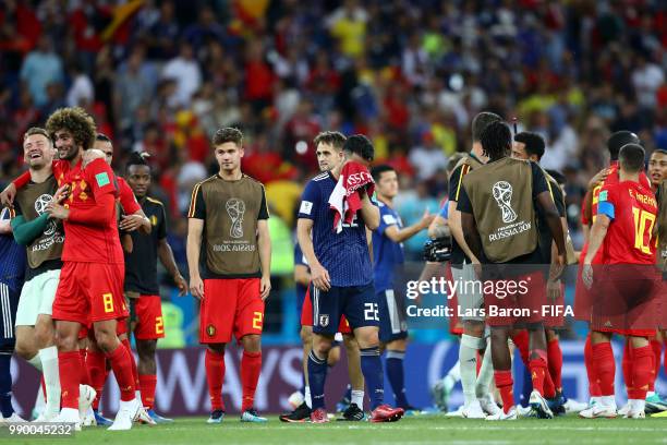 Belgium players celebrate as Maya Yoshida of Japan looks dejected following Japan's defeat in during the 2018 FIFA World Cup Russia Round of 16 match...