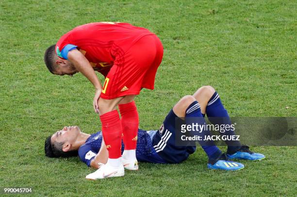 Belgium's forward Eden Hazard consoles Japan's midfielder Shinji Kagawa as he lies on the ground at the end of the Russia 2018 World Cup round of 16...