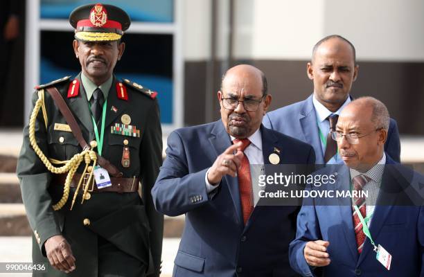 Sudan's President Omar al-Bashir walks with officials as he leaves the African Union summit in Nouakchott on July 2