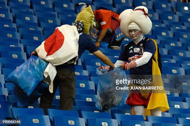 Japan supporters collect rubbish after the Russia 2018 World Cup round of 16 football match between Belgium and Japan at the Rostov Arena in...