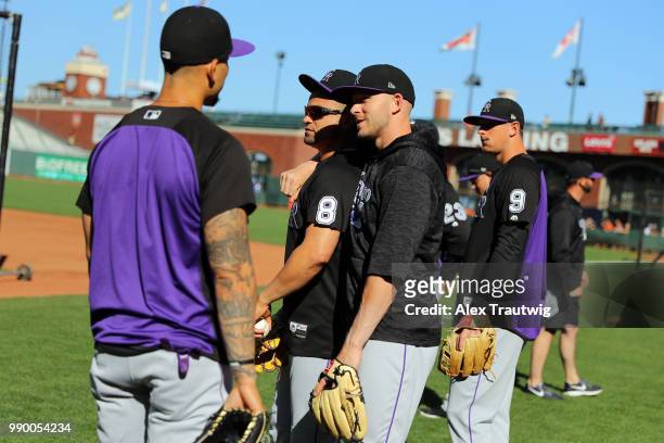 Trevor Story speaks with Gerardo Parra and Carlos Gonzalez of the Colorado Rockies during batting practice ahead of a game against the San Francisco...