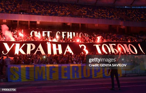 People hold banners reading "Oleg Sentsov, Ukraine with you!" as they attend a meeting at the NSC Olimpiysky stadium in Kiev on July 2 to demand the...