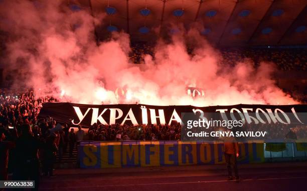 People hold banners reading "Oleg Sentsov, Ukraine with you!" as they attend a meeting at the NSC Olimpiysky stadium in Kiev on July 2 to demand the...