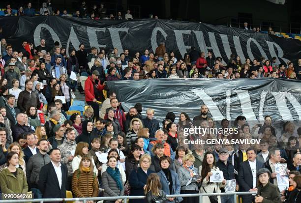 People hold banners reading "Oleg Sentsov, Ukraine with you!" as they attend a meeting at the NSC Olimpiysky stadium in Kiev on July 2 to demand the...