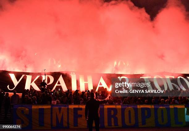 People hold banners reading "Oleg Sentsov, Ukraine with you!" as they attend a meeting at the NSC Olimpiysky stadium in Kiev on July 2 to demand the...