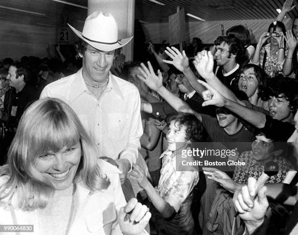 Boston Celtics player John Havlicek and his wife Beth pass by screaming fans as the team arrives at Logan Airport in Boston from Phoenix after...