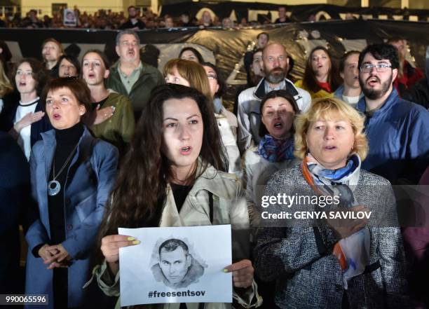 People sing the Ukrainian National anthem during a meeting at the NSC Olimpiysky stadium in Kiev on July 2 to demand the release Ukrainian film...