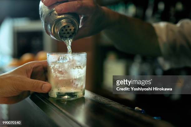 close-up of bartender hand pouring cocktail - business cocktail stock-fotos und bilder